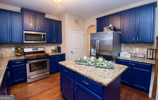 kitchen with appliances with stainless steel finishes, a center island, and blue cabinets