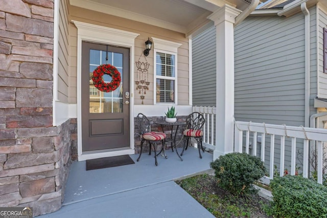 view of exterior entry featuring covered porch