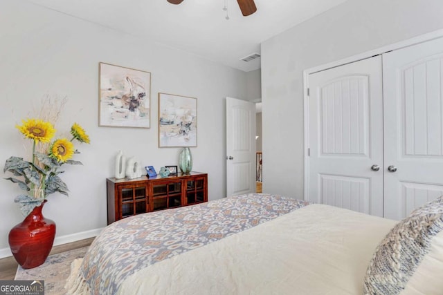 bedroom with hardwood / wood-style flooring, ceiling fan, and a closet