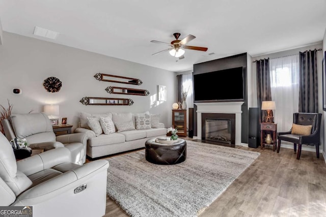 living room with ceiling fan and light hardwood / wood-style floors