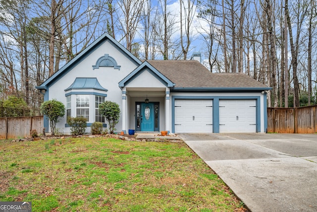 view of front of property with driveway, a front yard, a garage, and fence