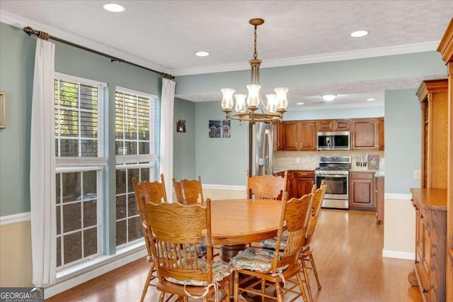 dining area with baseboards, light wood finished floors, recessed lighting, ornamental molding, and a notable chandelier