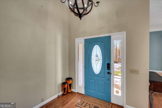 entrance foyer featuring hardwood / wood-style flooring and a notable chandelier