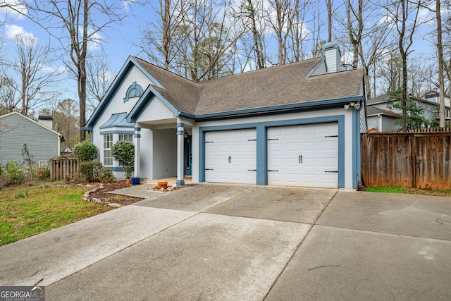 view of front facade featuring an attached garage, a shingled roof, driveway, and fence