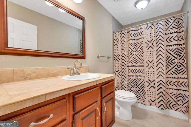 full bathroom featuring tile patterned floors, toilet, vanity, and a textured ceiling
