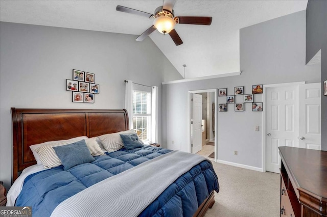 bedroom featuring a ceiling fan, baseboards, high vaulted ceiling, ensuite bath, and light colored carpet