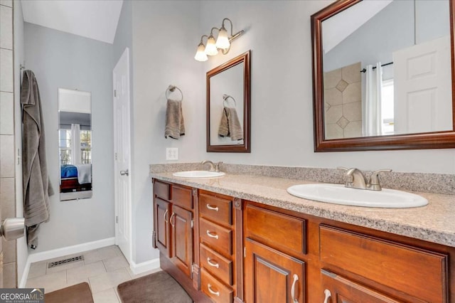 bathroom with tile patterned floors, double vanity, visible vents, and a sink