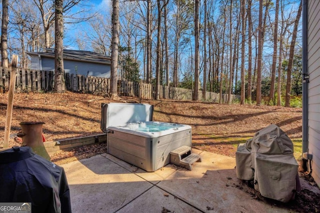 view of yard featuring a patio, fence, and a hot tub