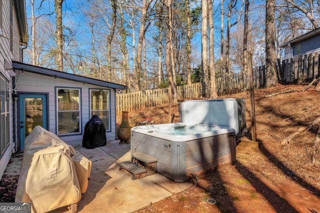 view of patio with a fenced backyard and a hot tub