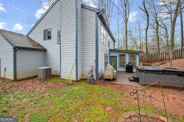 rear view of property with a patio, a hot tub, central AC, and fence