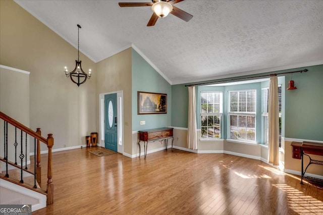 foyer featuring baseboards, a textured ceiling, wood finished floors, and stairs