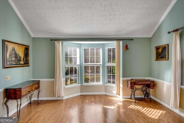 interior space featuring crown molding, baseboards, and wood finished floors