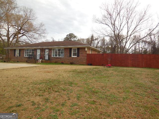 single story home with a front lawn