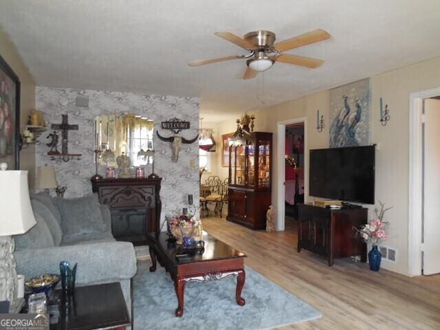 living room with ceiling fan and wood-type flooring