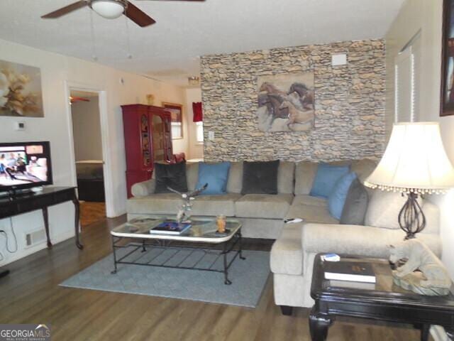 living room featuring ceiling fan and wood-type flooring