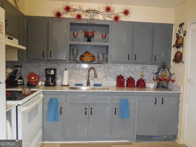 kitchen with gray cabinets, sink, tasteful backsplash, and white range with electric cooktop