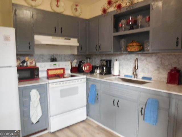 kitchen featuring sink, backsplash, white appliances, and light wood-type flooring