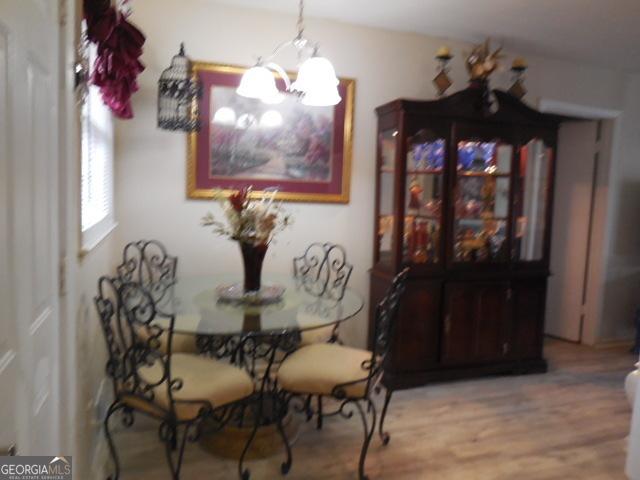 dining area with hardwood / wood-style floors and a chandelier