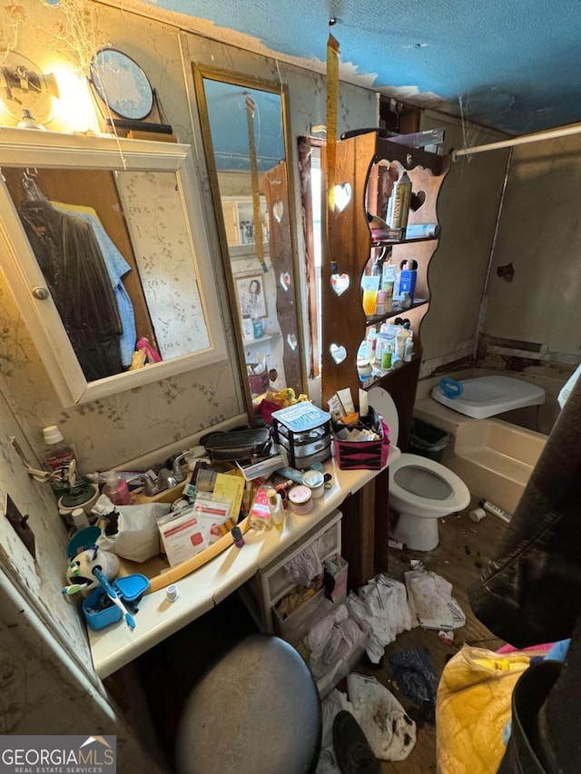 bathroom featuring a textured ceiling and toilet