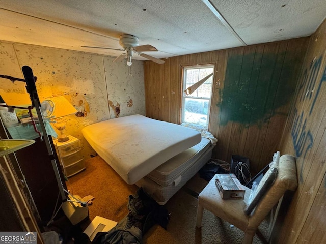 bedroom with a textured ceiling and wood walls