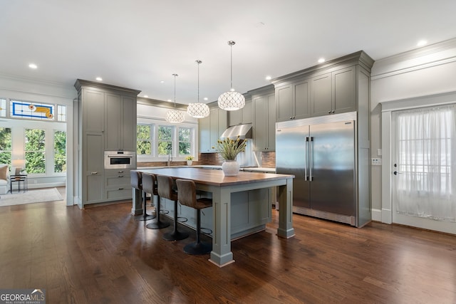 kitchen with gray cabinets, decorative backsplash, appliances with stainless steel finishes, and decorative light fixtures