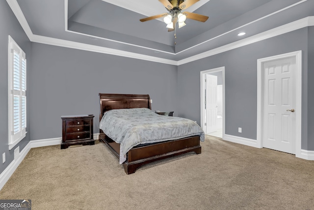 bedroom with carpet floors, a tray ceiling, ornamental molding, and baseboards