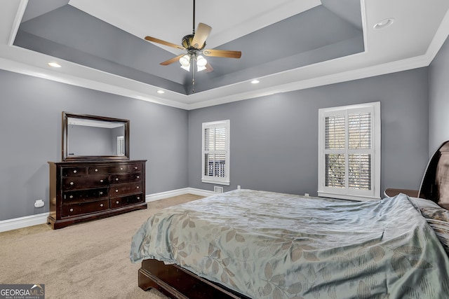 carpeted bedroom featuring ornamental molding, a tray ceiling, and baseboards