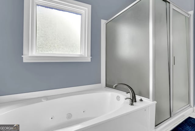 bathroom featuring a stall shower and a garden tub