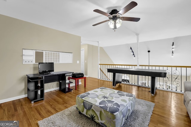 interior space featuring a ceiling fan, baseboards, and wood finished floors