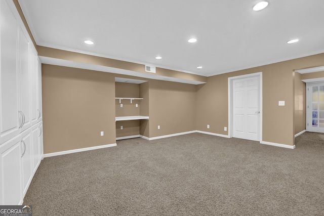 below grade area featuring recessed lighting, baseboards, built in desk, and carpet flooring