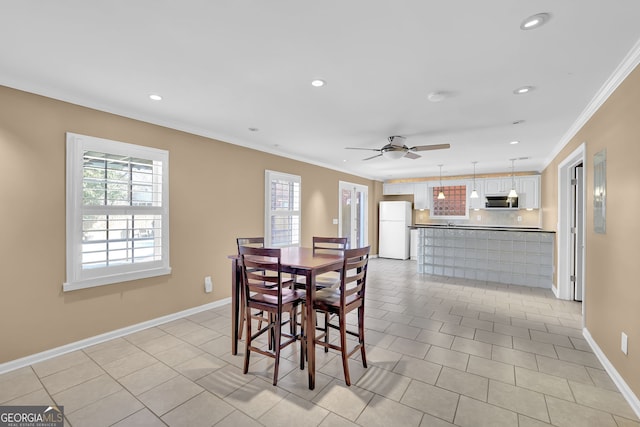 dining space featuring ornamental molding, baseboards, and light tile patterned floors