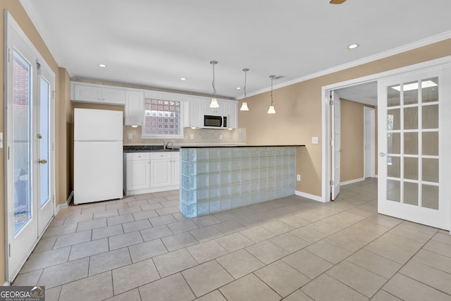 kitchen with freestanding refrigerator, white cabinetry, crown molding, and light tile patterned floors