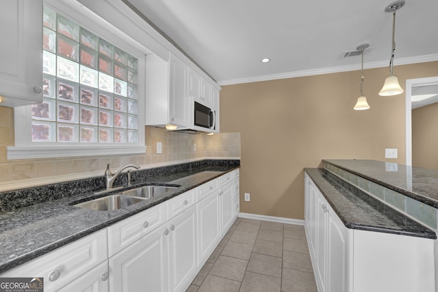 kitchen featuring crown molding, light tile patterned floors, backsplash, white cabinetry, and a sink