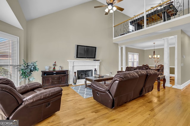 living room with light wood-type flooring, decorative columns, and a fireplace