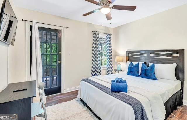 bedroom featuring access to exterior, dark hardwood / wood-style floors, and ceiling fan