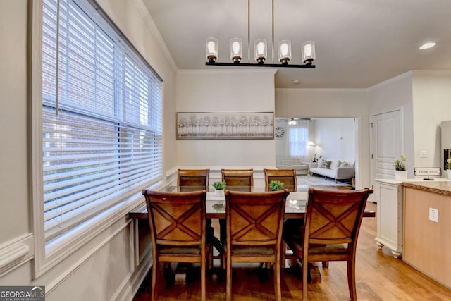 dining room with light wood-type flooring, breakfast area, and crown molding