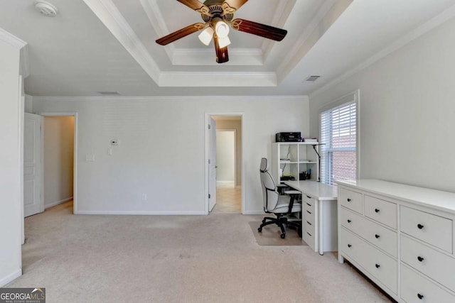 office space with a raised ceiling, ceiling fan, light colored carpet, and ornamental molding