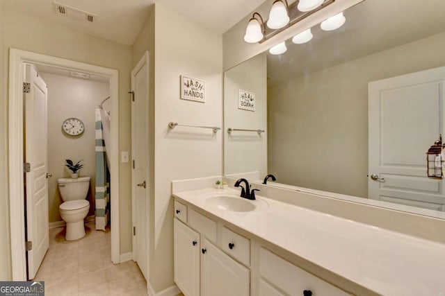 bathroom featuring toilet, vanity, tile patterned flooring, and walk in shower