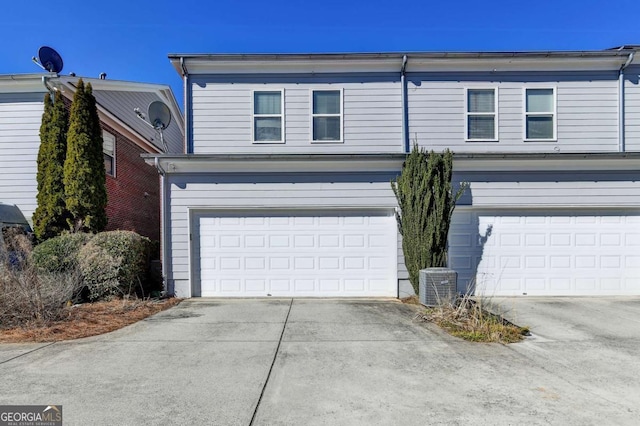 view of front of property featuring a garage and cooling unit