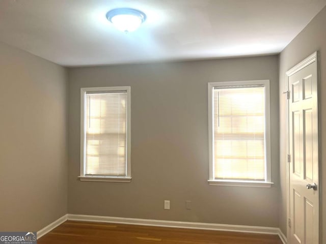 unfurnished room with dark wood-type flooring