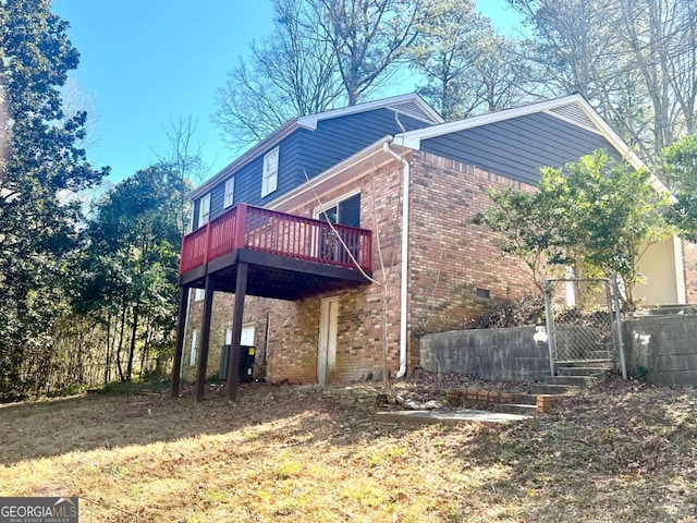 view of side of home with a yard and a wooden deck