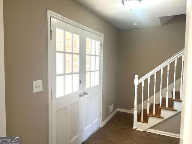 entryway featuring french doors and dark tile patterned floors