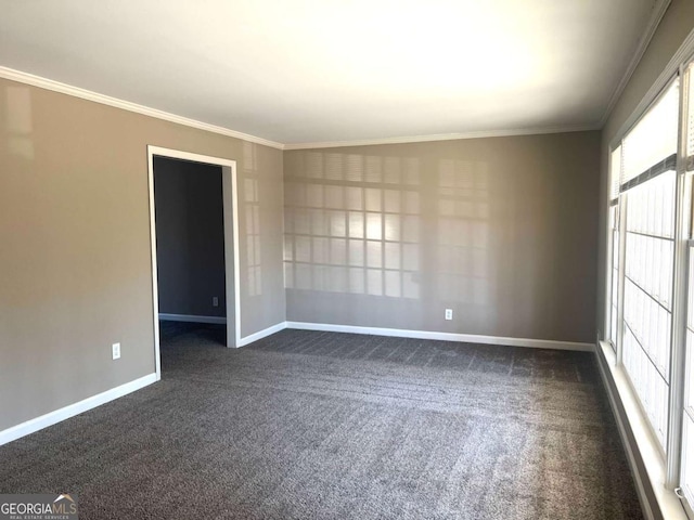 spare room featuring dark carpet and crown molding