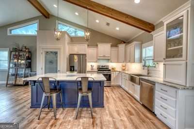 kitchen with white cabinetry, appliances with stainless steel finishes, a kitchen island, and a kitchen breakfast bar