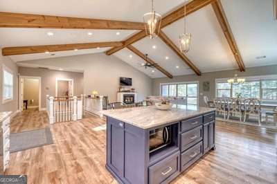 kitchen featuring light hardwood / wood-style flooring, a kitchen island, a notable chandelier, and pendant lighting