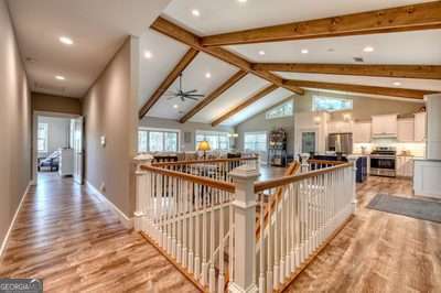 hall featuring light hardwood / wood-style flooring, high vaulted ceiling, and beamed ceiling