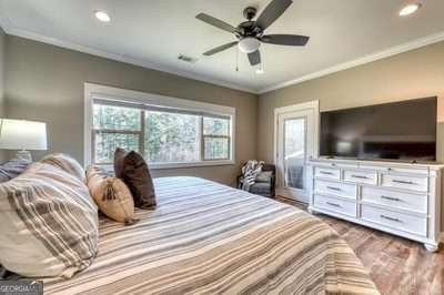 bedroom featuring hardwood / wood-style floors, ceiling fan, and crown molding