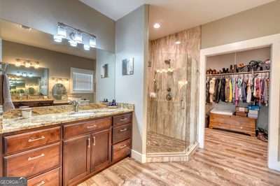 bathroom with vanity, a shower, and wood-type flooring