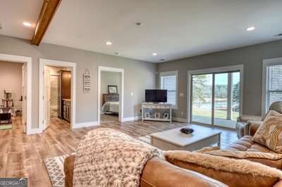 living room featuring light hardwood / wood-style floors and beamed ceiling