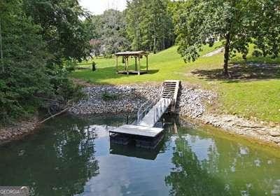 dock area featuring a water view, a lawn, and a gazebo